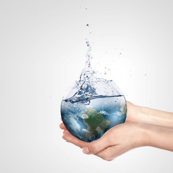 Persona sostiene envas con forma del planeta tierra llenándose de agua