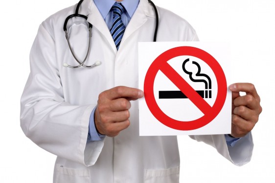 Doctor sosteniendo letrero de no fumar