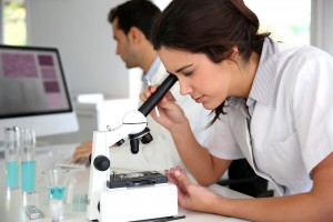 Investigadora observando microscopio