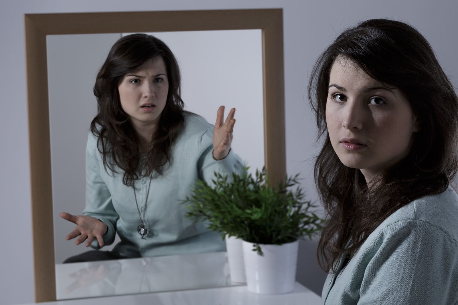 Mujer reflejada en un espejo con actitud diferente