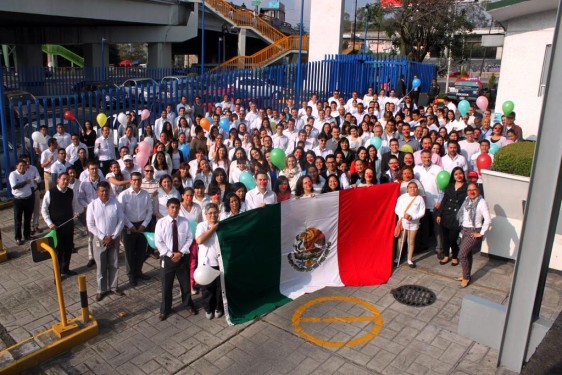 Empleados de Riche México y participantes con una bandera de México