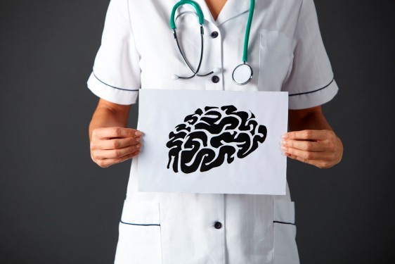 Enfermera sosteniendo letrero con ilustración de un cerebro
