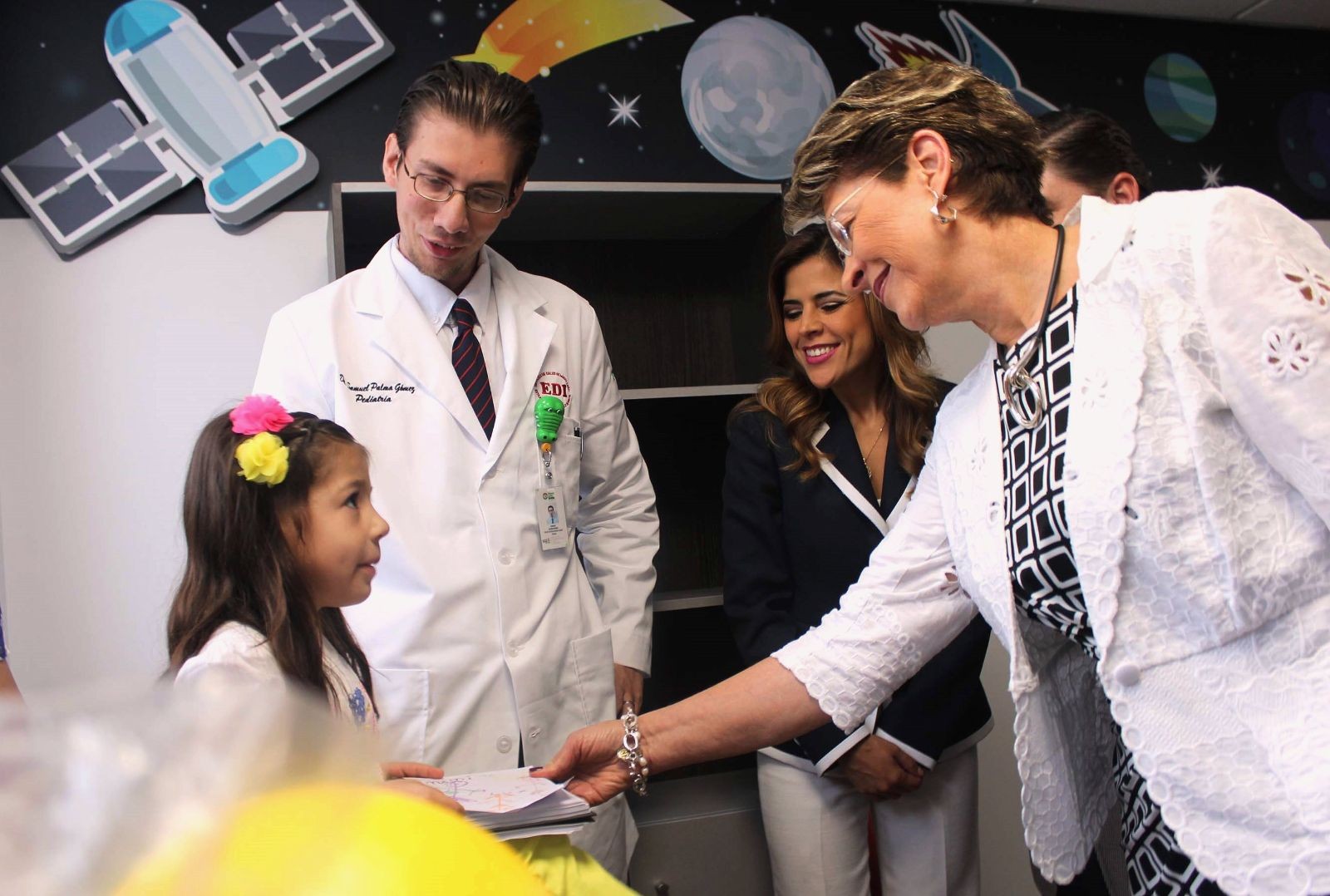 Mercedes Juan conversa con una niña siendo acompañados por un médico