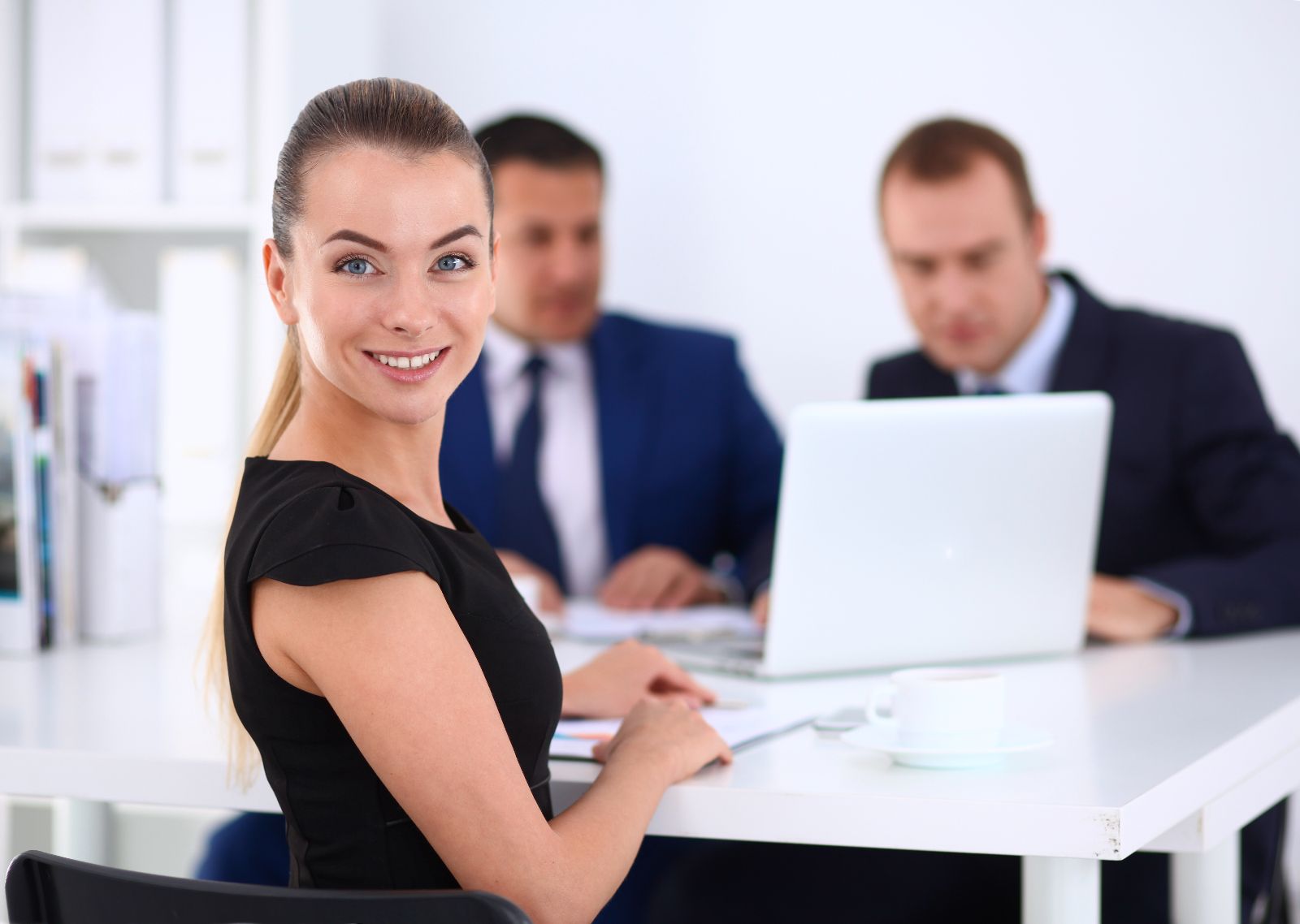 Mujer sonriendo con colegas en el fondo