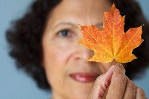 Mujer de más de cincuenta años con una hoja de otoño