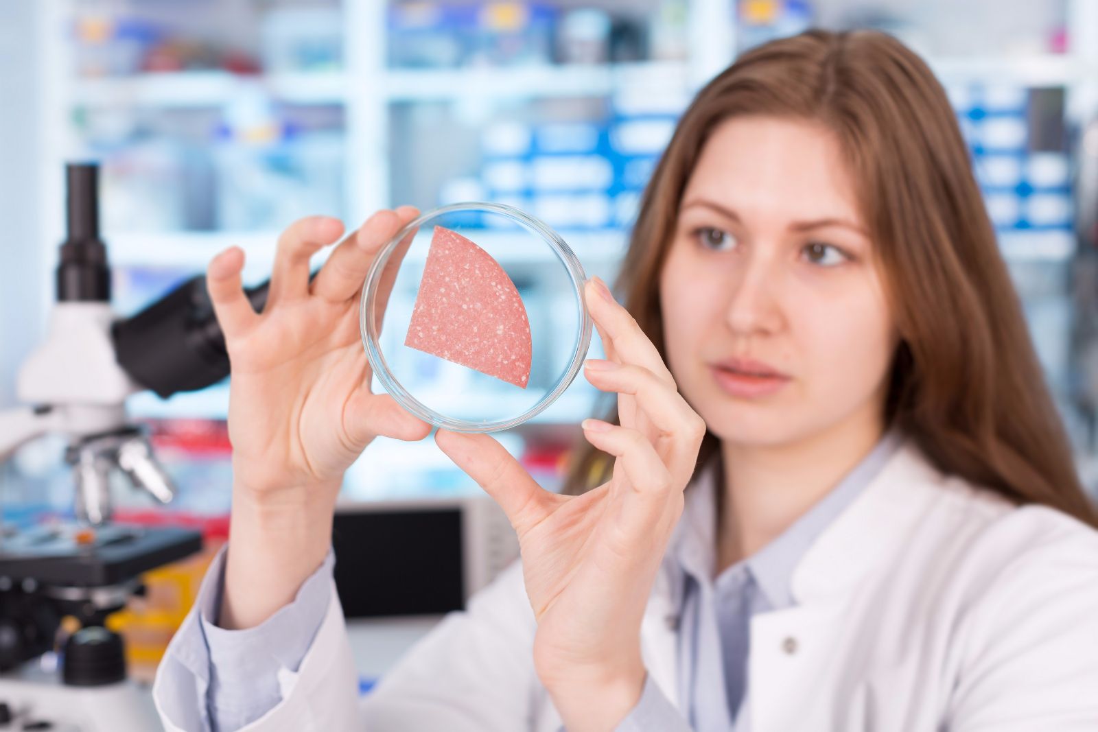 Mujer en laboratorio observando muestra de un alimento