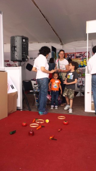 Educadora mostrando a niños un juego con alimentos