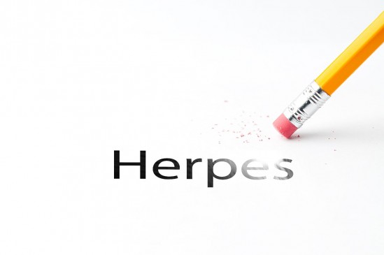 Lápiz borrando la palabra HERPES