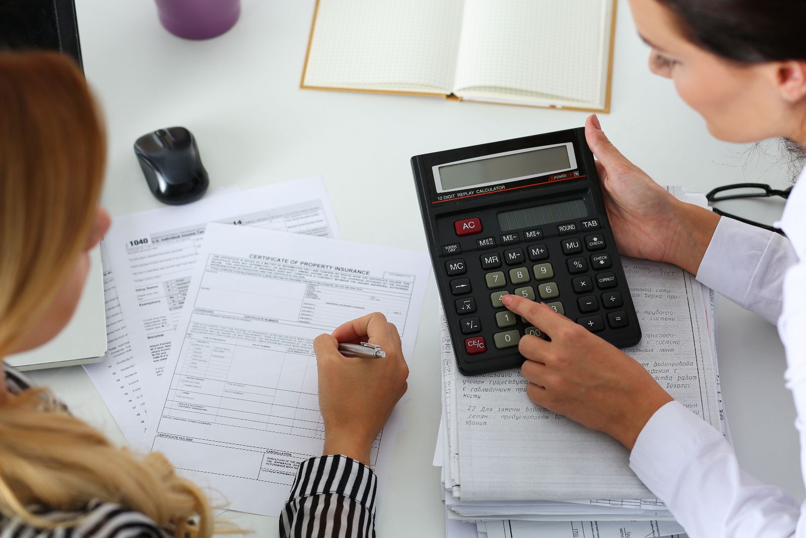 dos mujeres con una calculadora haciendo operaciones