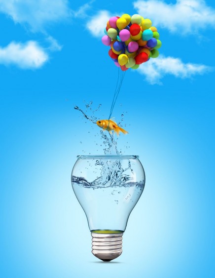 Gold fish flying away from a lightbulb with the help of a balloons