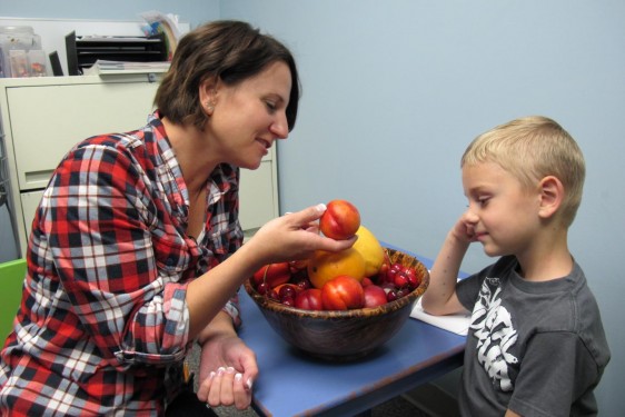 Madre ofrece una fruta a su hijo