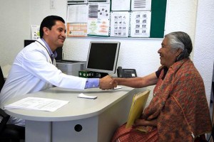 Médico saluda de mano a adulta mayor indígena