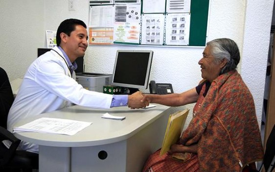 Médico saluda de mano a adulta mayor indígena