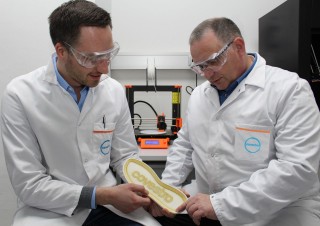 Lukas Breuers y Dr. Jörg Tillack examinan una suela de calzado con una impresión adhesiva.