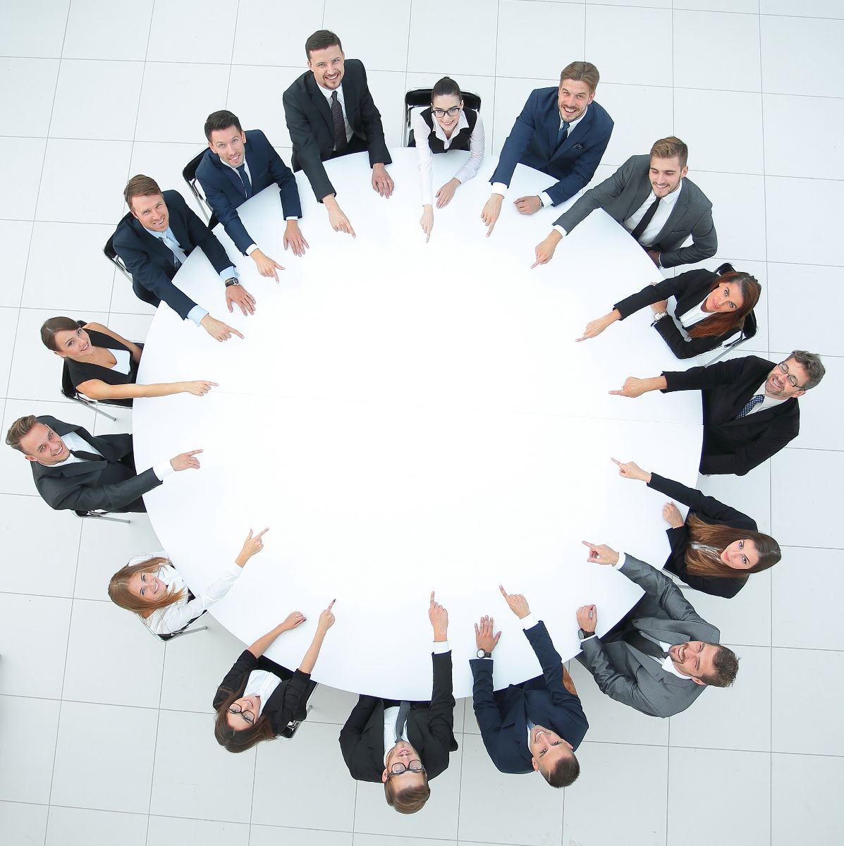 grupo de ejecutivos apuntando al centro de una mesa