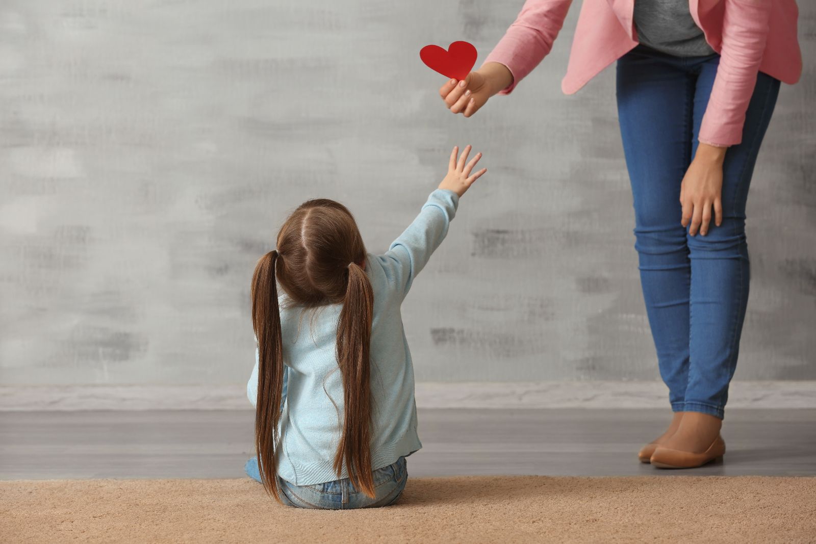 niña recibiendo un recorte en forma de corazón