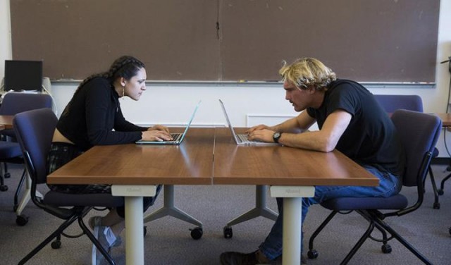Dos estudiantes de la Universidad Estatal de San Francisco muestran la postura en la que las personas se comprimen el cuello en la computadora.