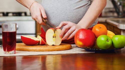 mujer embarazada preparando alimentos saludables