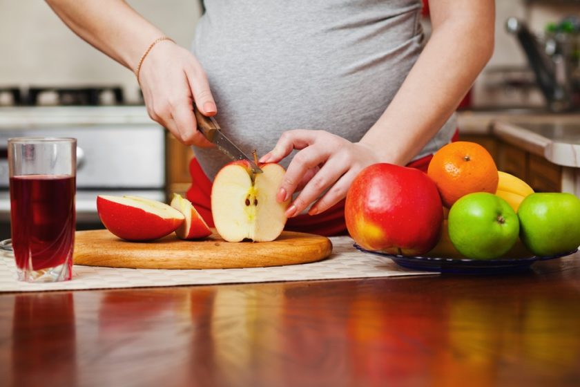 mujer embarazada preparando alimentos saludables