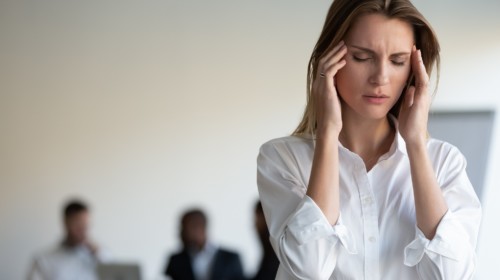 mujer sufren dolor de cabeza debido al estrés en el lugar de trabajo.