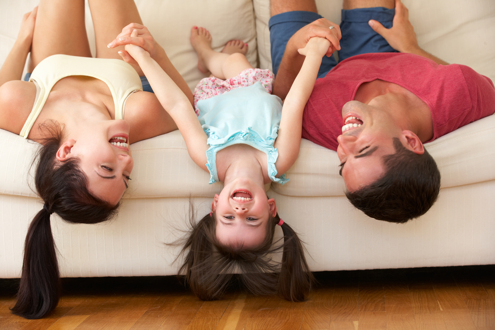 familia acostada en sillón divertida y sonriendo