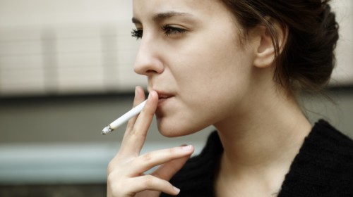 mujer joven fumando un cigarro