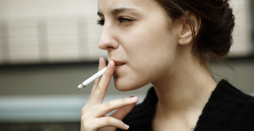 mujer joven fumando un cigarro