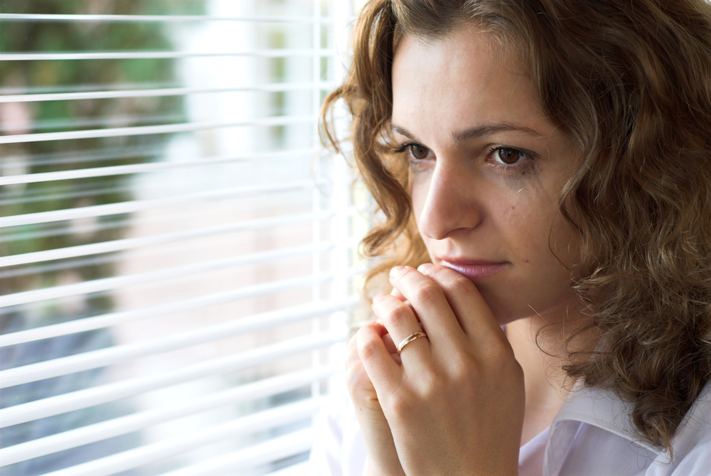 Mujer con ansiedad frente a la ventana