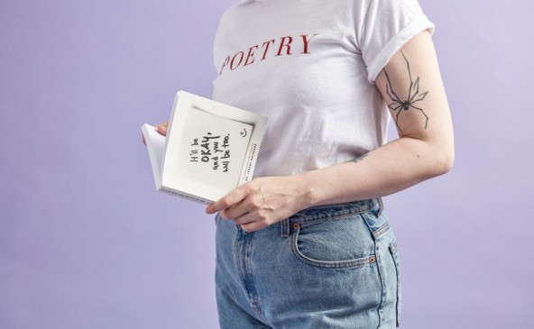 chica joven tomando un libro de poesía entre sus manos