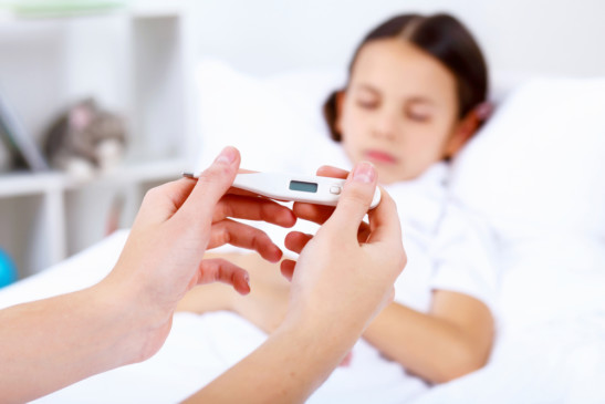 niña en cama con fiebre