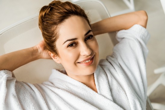 mujer sonriente en bata de baño