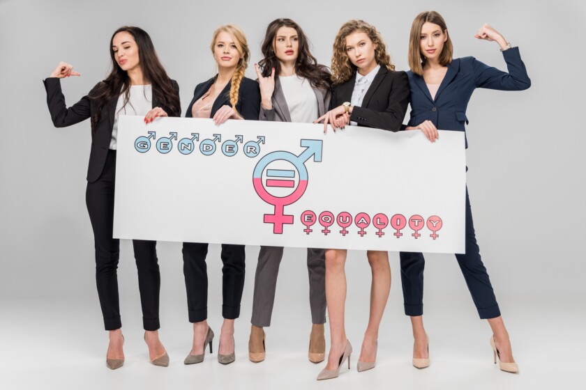 Jóvenes empresarias con gran cartel con el símbolo de la igualdad