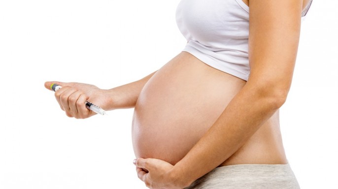 mujer embarazada con inyección aplicando insulina