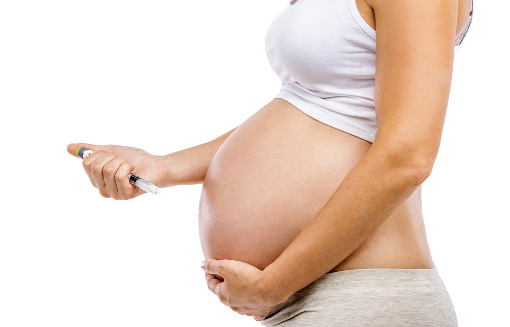 mujer embarazada con inyección aplicando insulina