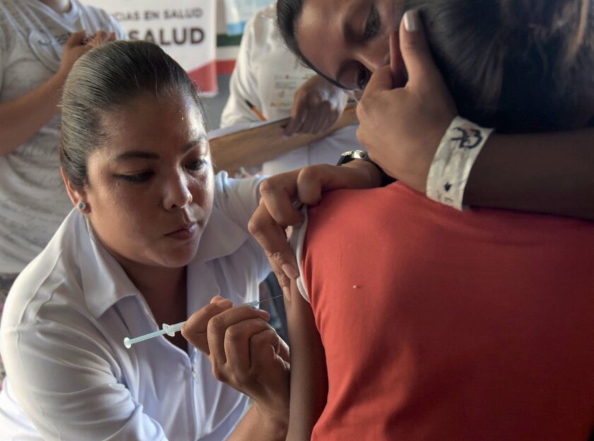 Enfermera vacunando a menor