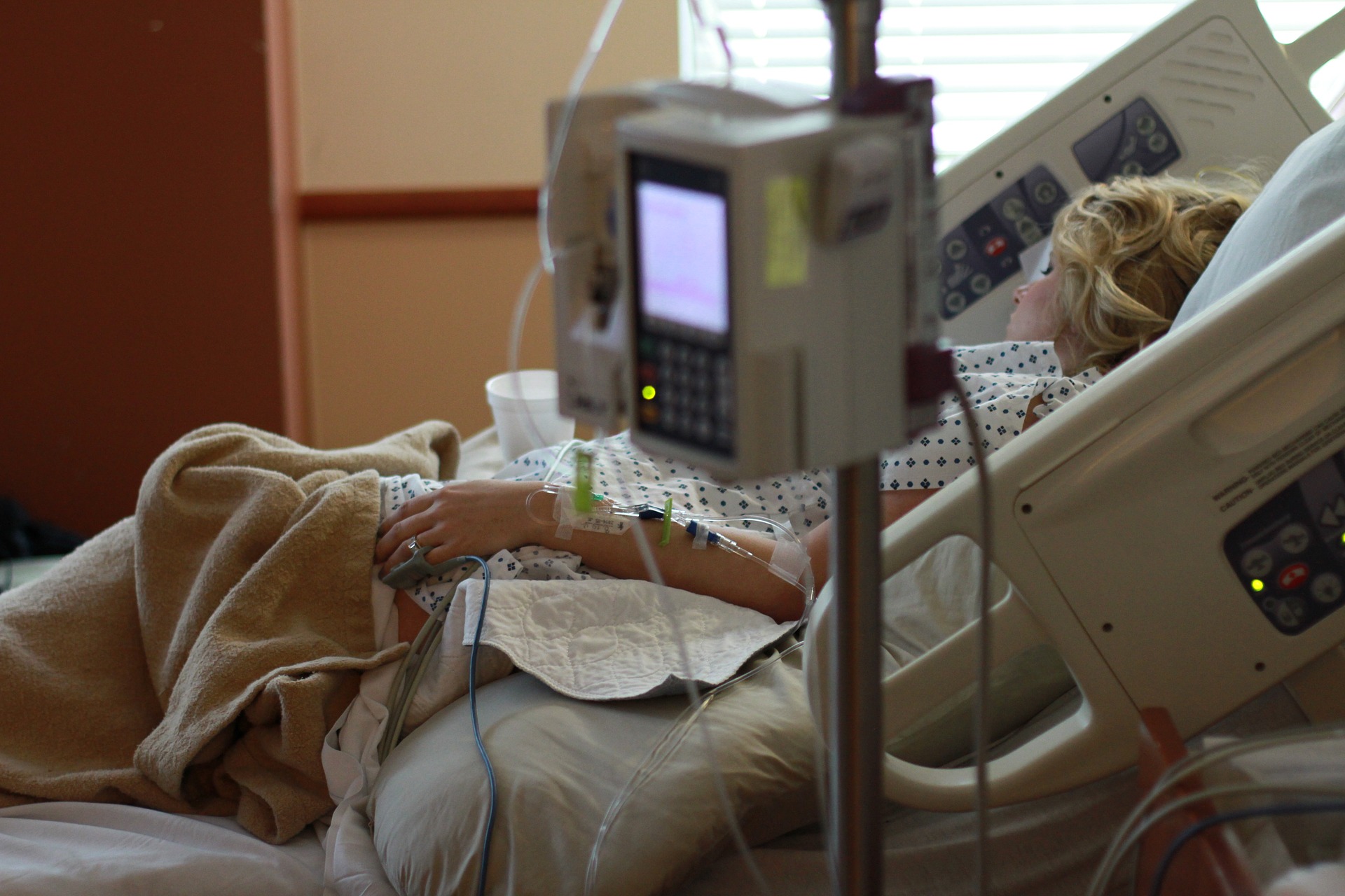 Mujer en cama de hospital.