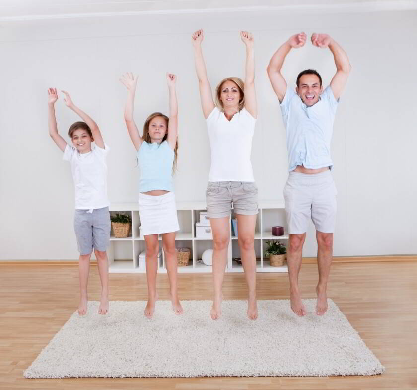 Familia haciendo ejercicios de estiramiento en la alfombra