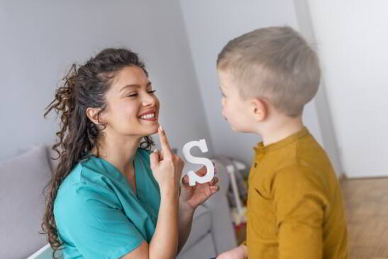 Logopeda enseñando a niño a decir letra S