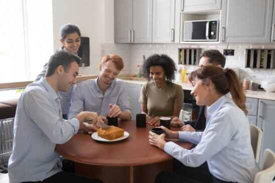 personas en una oficina comiendo un pastel casero