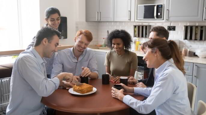 personas en una oficina comiendo un pastel casero