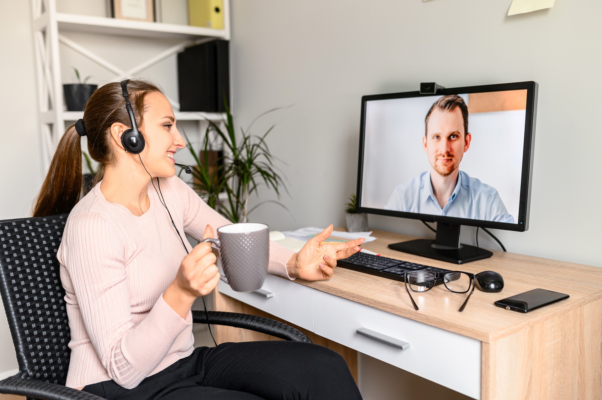 joven utiliza auriculares para hablar en videoconferencia