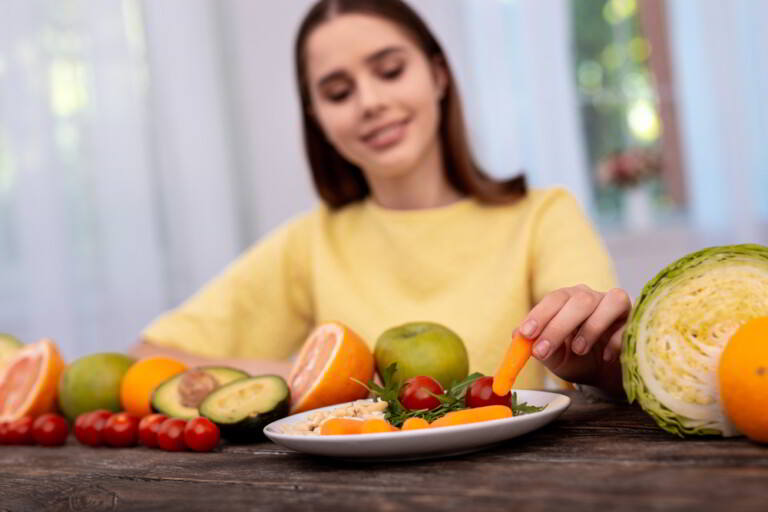 Mujer comiendo zanahoria fresca y tomates para el desayuno