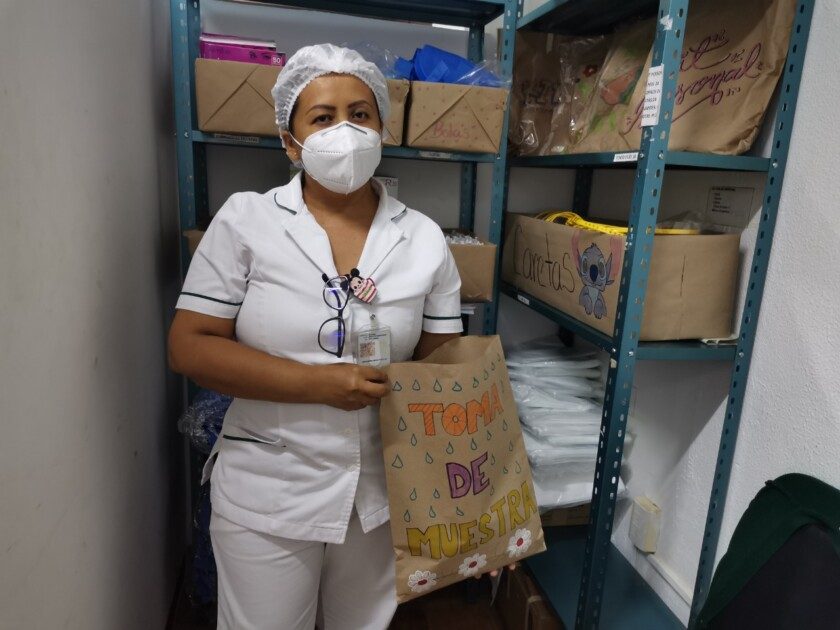 Juana y Laura, enfermeras de la Unidad de Medicina Familiar (UMF) No. 26 del Instituto Mexicano del Seguro Social (IMSS) en Acapulco, decoran y escriben frases motivacionales en los empaques de papel del Equipo de Protección Personal (EPP)
