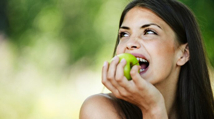 joven mujer mordiendo manzana