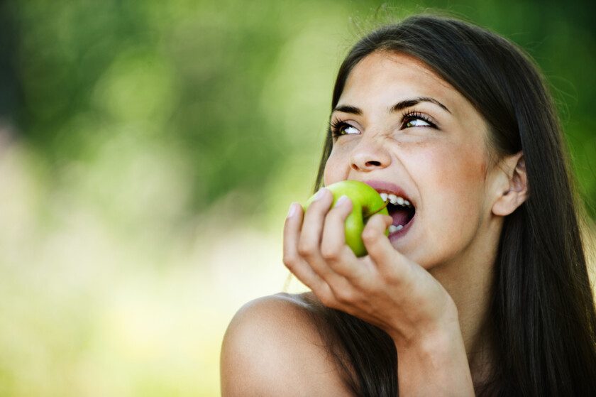joven mujer mordiendo manzana