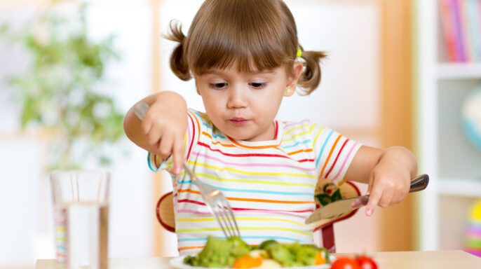 Niño que come alimentos saludables en casa o en el jardín de infantes