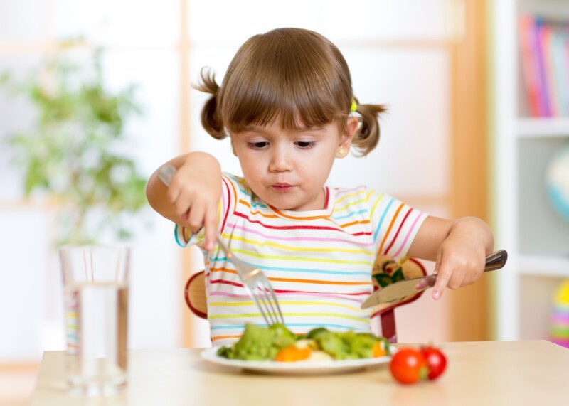 Niño que come alimentos saludables en casa o en el jardín de infantes