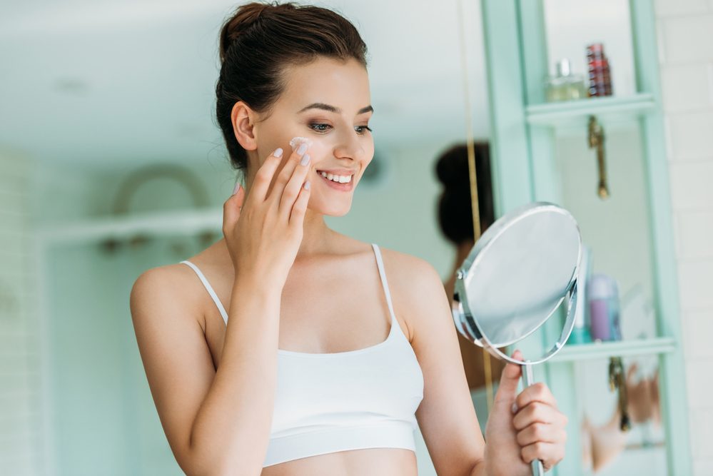 Mujer sonriente cuidando la piel