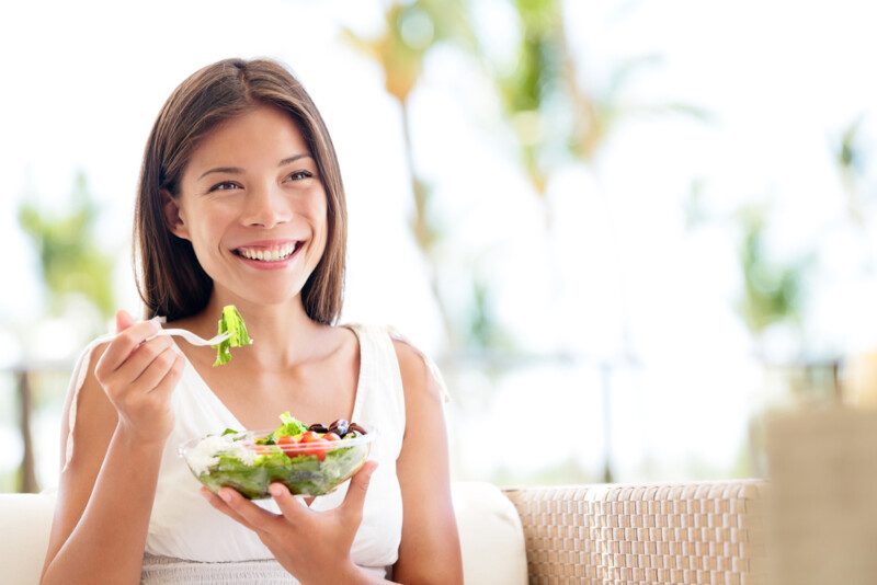 Estilo de vida saludable mujer comiendo ensalada sonriendo feliz