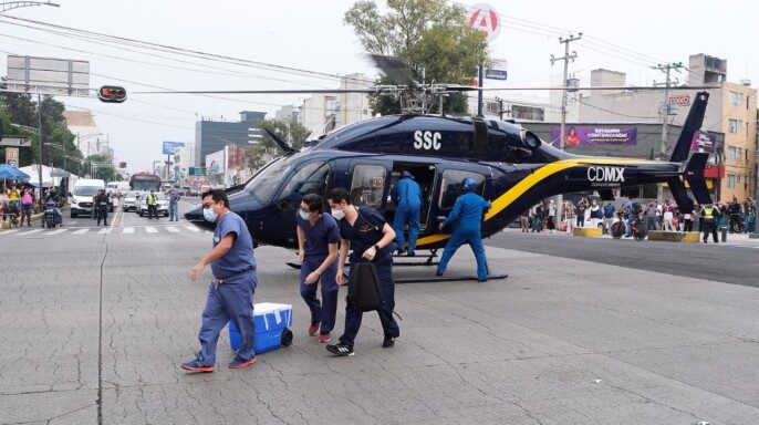 Personal médico trasladando contenedores desde un helicóptero